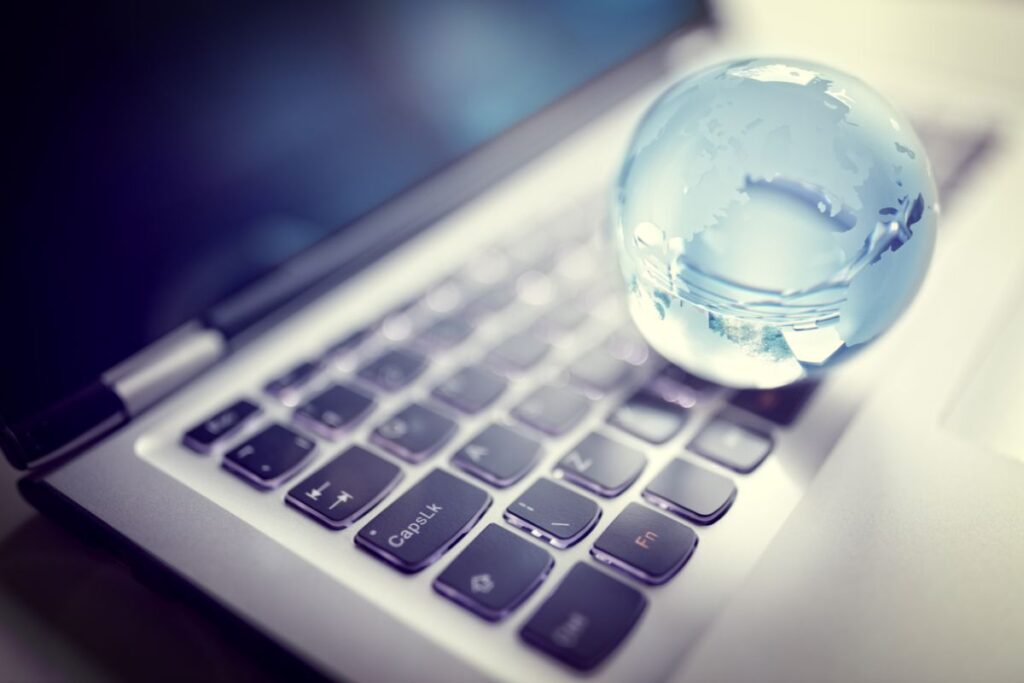 Globus auf Laptop als Symbol für internationale Kreditversicherung und weltweite Geschäftsbeziehungen